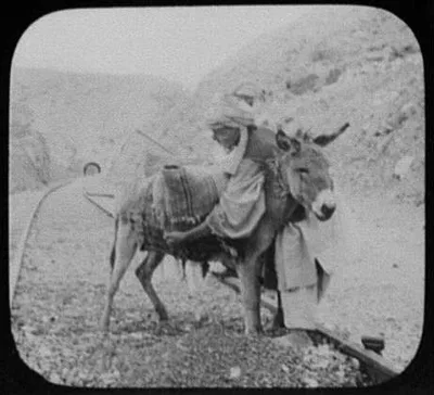 Indians and burro on railway tracks; tunnel entrance in background, Pakistan, 1895