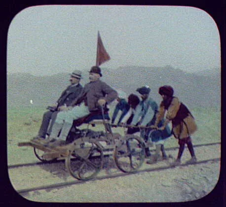 Four turbanned natives pushing Pangborn in hand-car in Bolan Pass, Pakistan, 1895