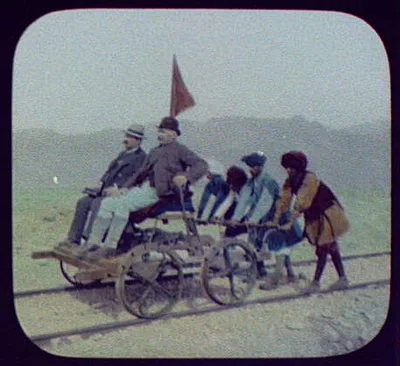 Four turbanned natives pushing Pangborn in hand-car in Bolan Pass, Pakistan, 1895