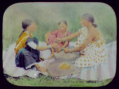 Three women grinding food on flat stones, India, 1895