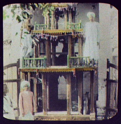 Two men standing on 2nd tier of 3-tiered shrine, India, 1895
