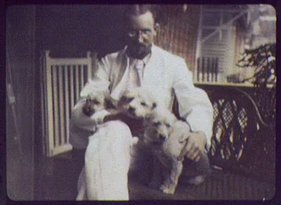 Indian puppies  - man holding 3 puppies on his lap, 1895
