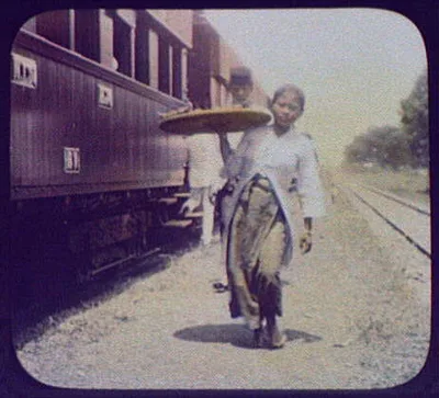 Woman selling refreshments from tray at railway station, Burma, 1895