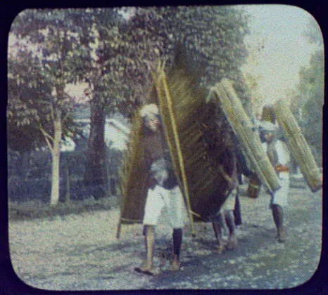 Three men carrying palm leaf and matting rain shields, Java, Indonesia, 1895
