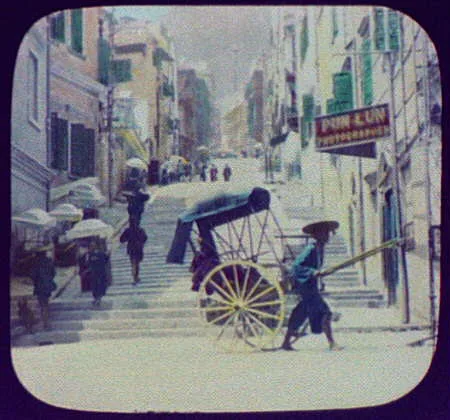 Street scene; shop of "Pun Lun, Photographer" in foreground, Hong Kong, 1895