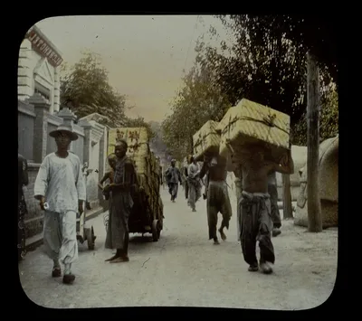 Coolies carrying boxes of tea beside Globe Hotel, China, 1895
