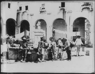 [Men with water vessels at well, Aguadores], 1884